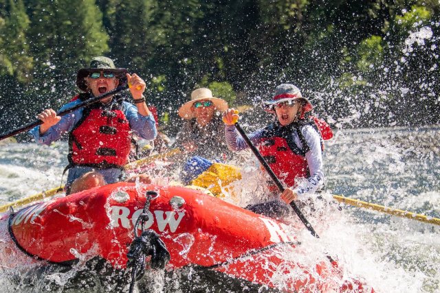 ROW rafting guests paddling through splashy whitewater rapids on a Rogue River rafting trip in Oregon.